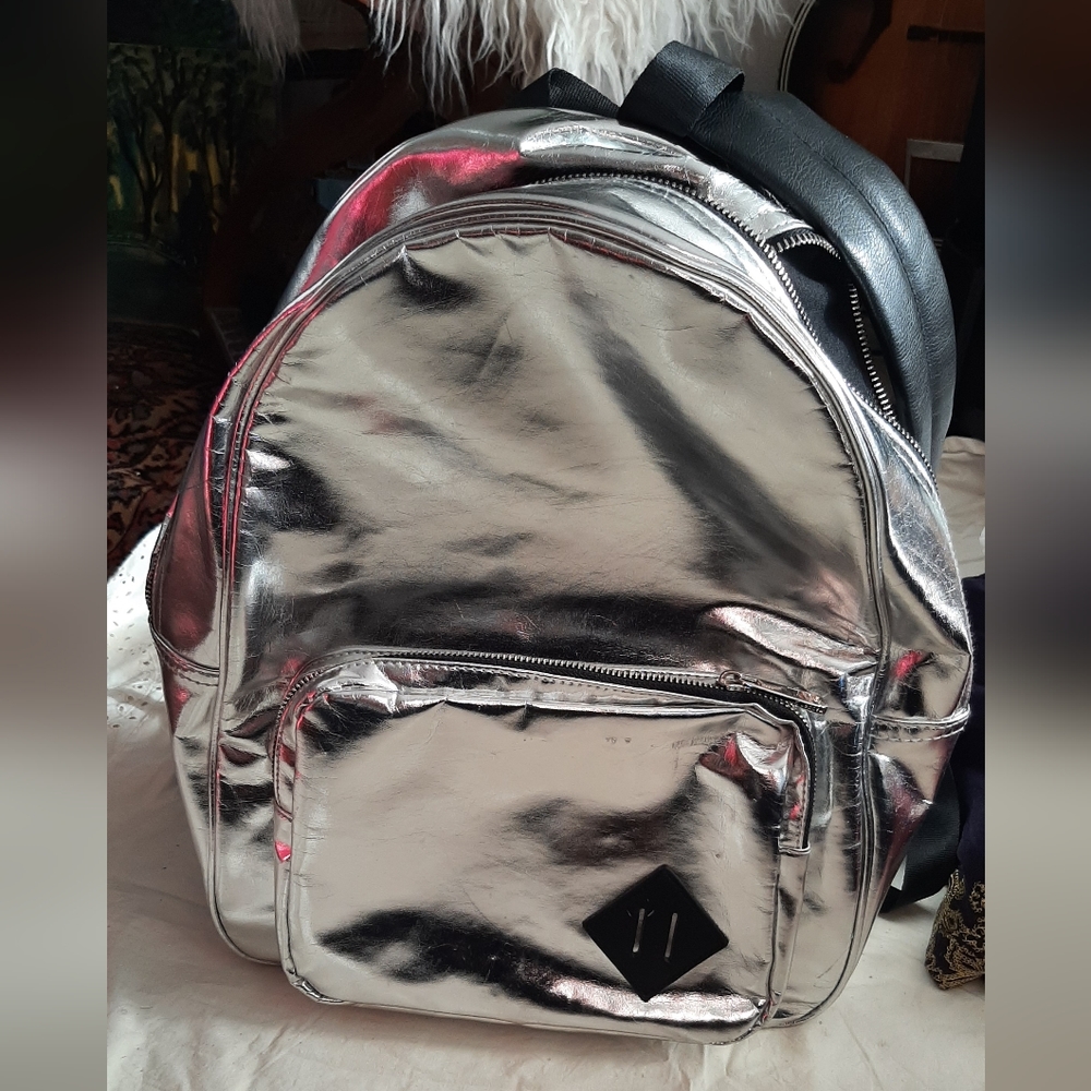 Silver bag Knapsack shoulder straps lots of pockets and zippers
